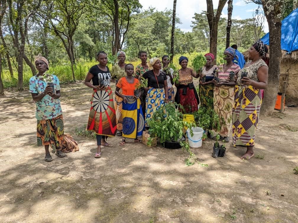 Community members in protective beekeeping suits with new beekeeping equipment
