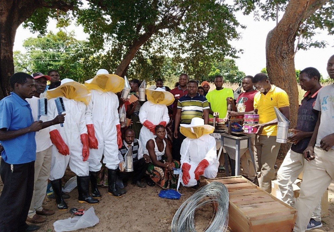 Community members displaying a harvest of pumpkins and vegetables